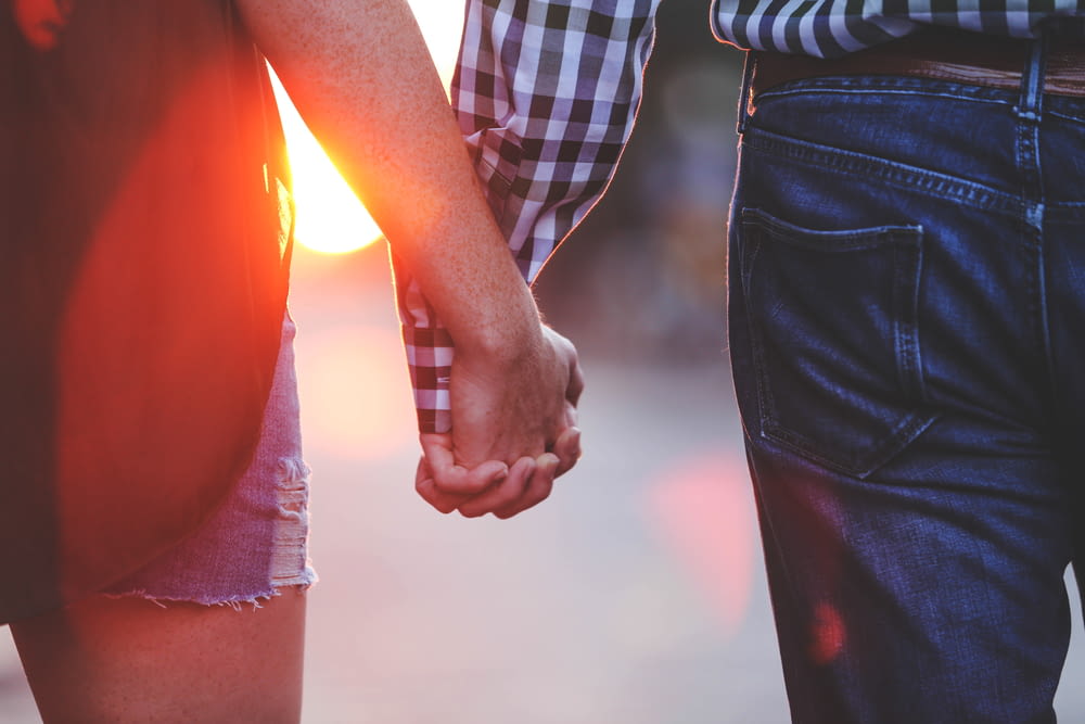 two person standing and holding hands together