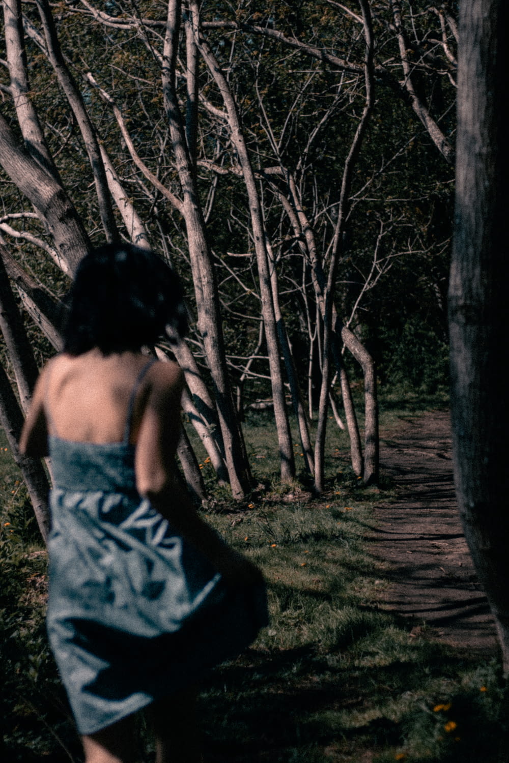 woman in grey mini cami dress running in woods