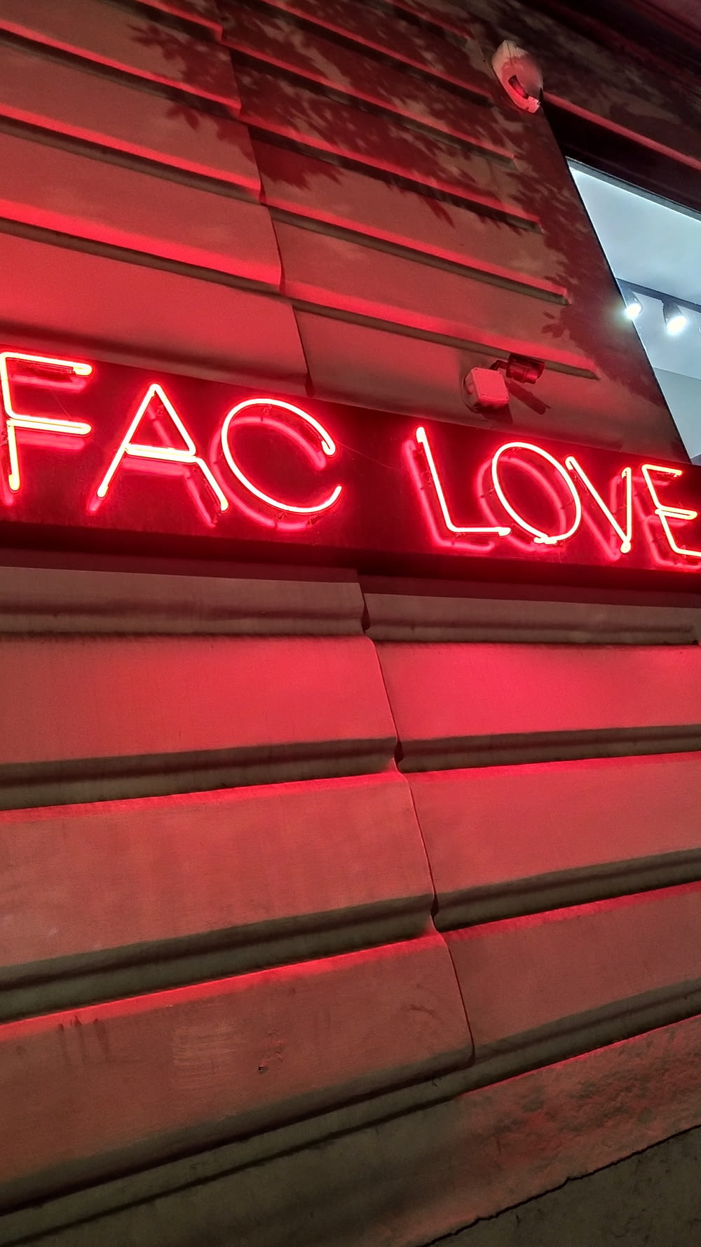 a neon sign that reads fac love on the side of a building
