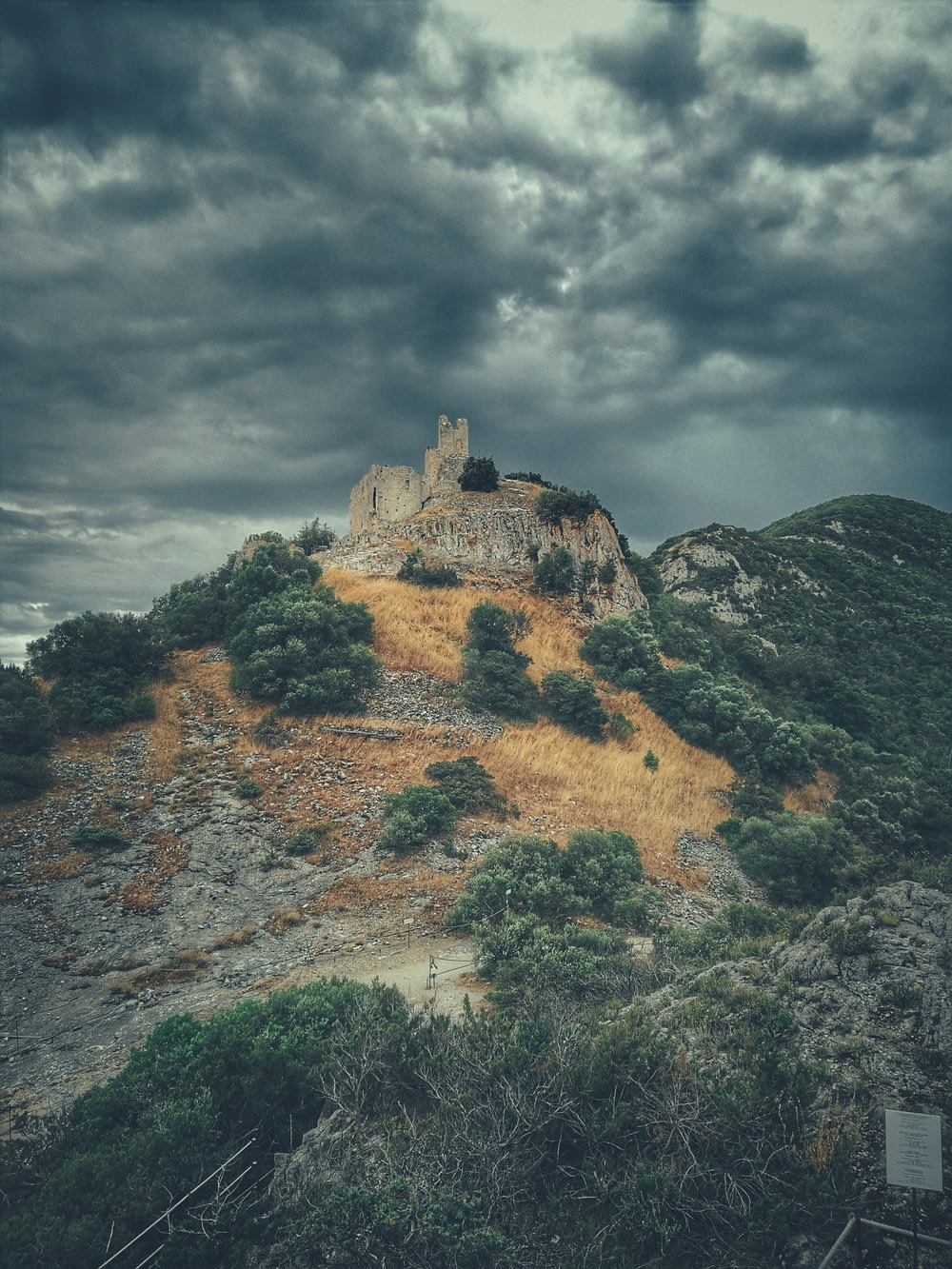 a castle sitting on top of a hill under a cloudy sky