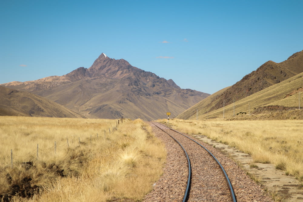 train track near mountains during day