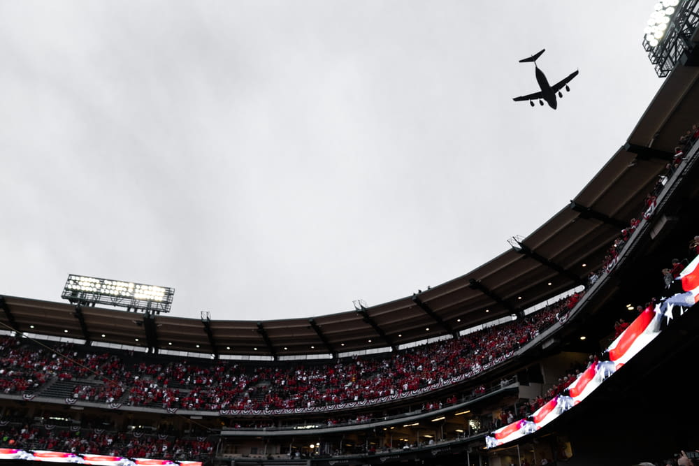 airplane flying above stadium