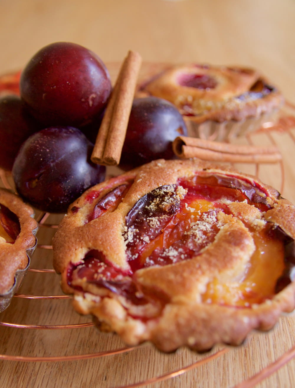 plum pies and cinnamon sticks on a wire rack
