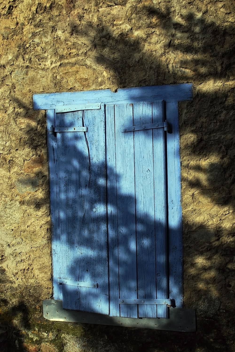 a blue wooden door sitting on the side of a building