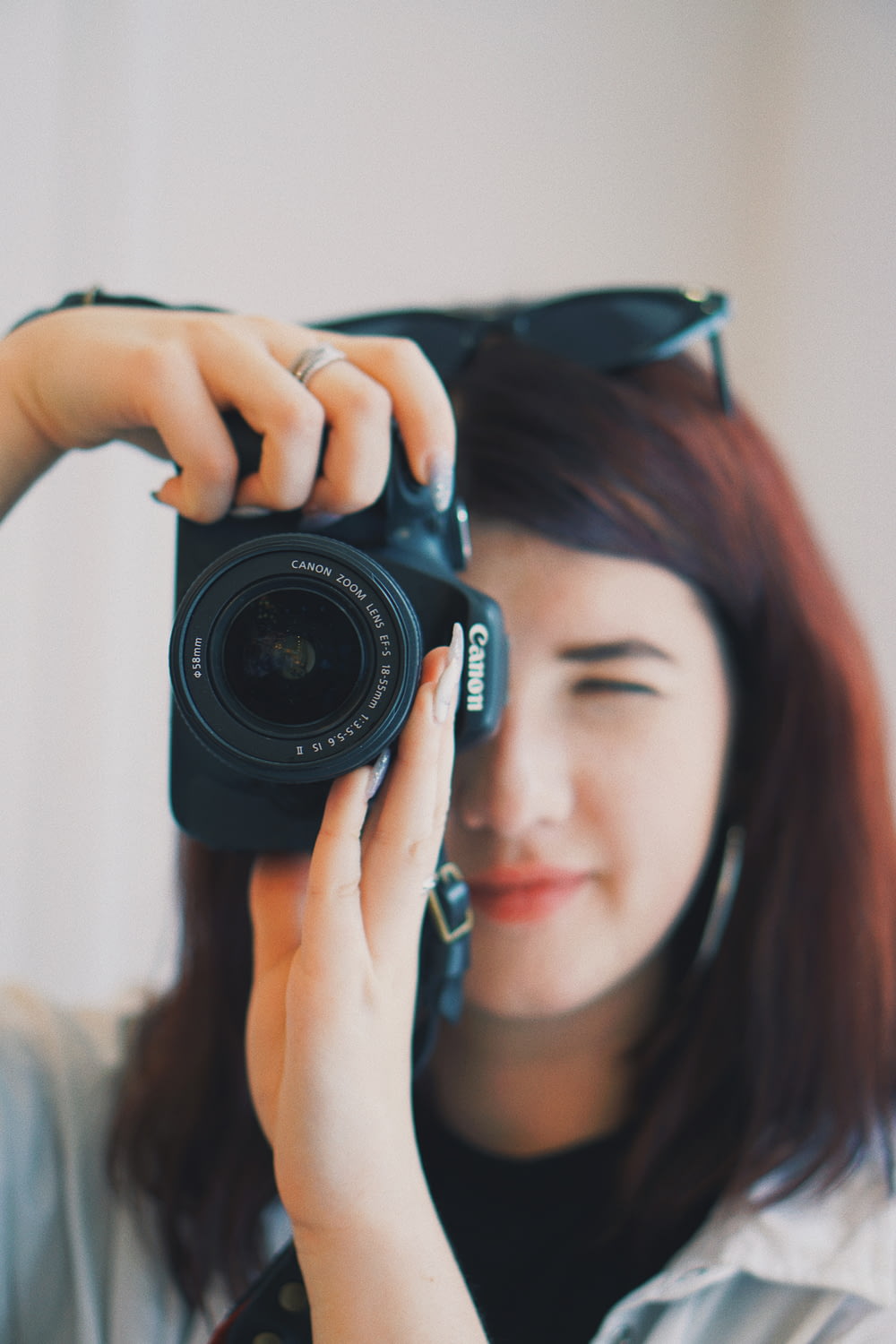 foto de foco raso da mulher usando a câmera DSLR Canon preta