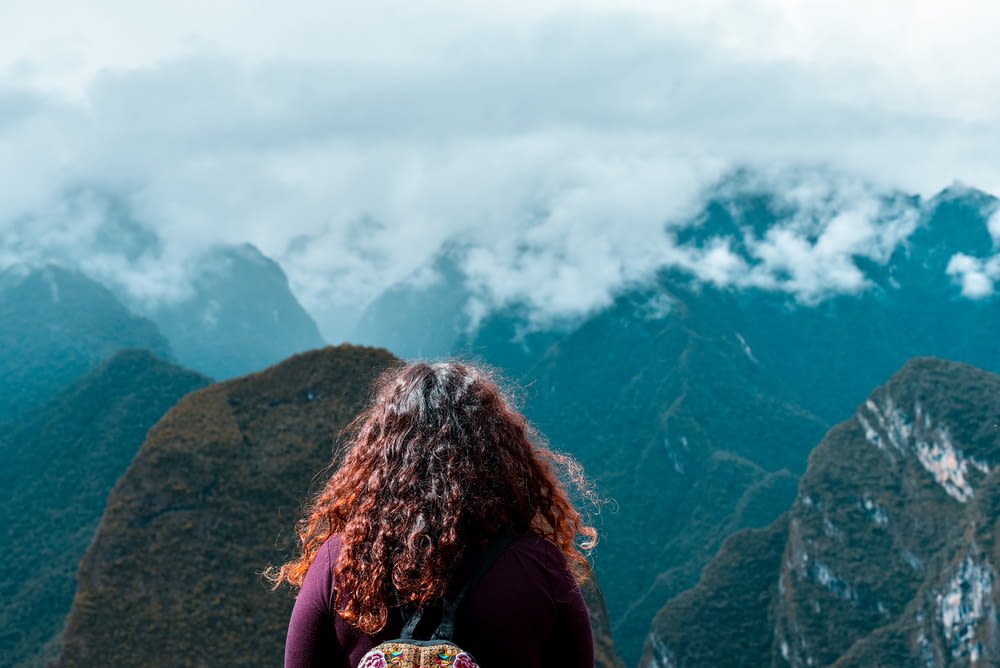 woman facing the mountains during day
