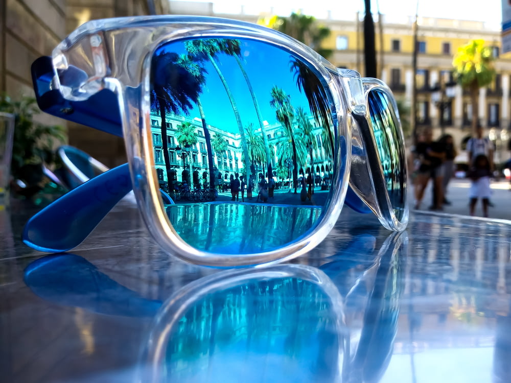 óculos de sol com armação cinza e azul na mesa cinza