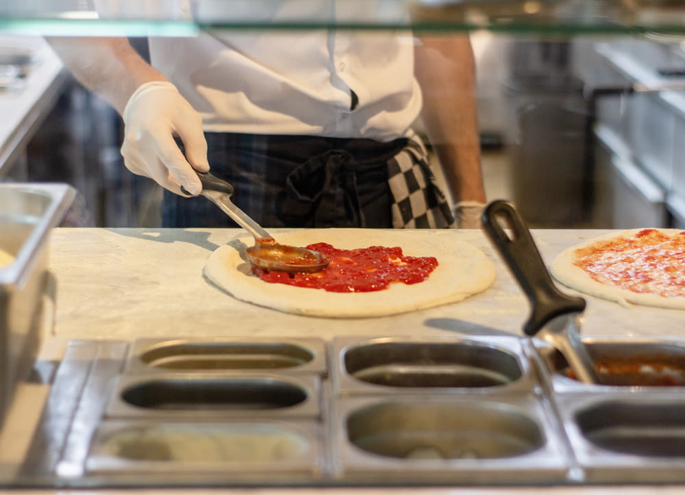 a chef is preparing pizzas in a kitchen