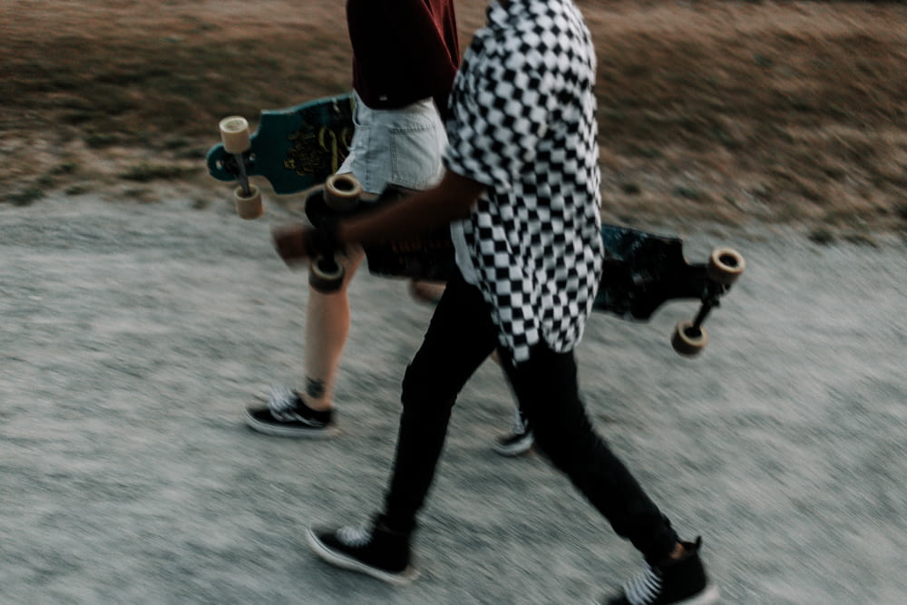 a couple of people that are walking with skateboards