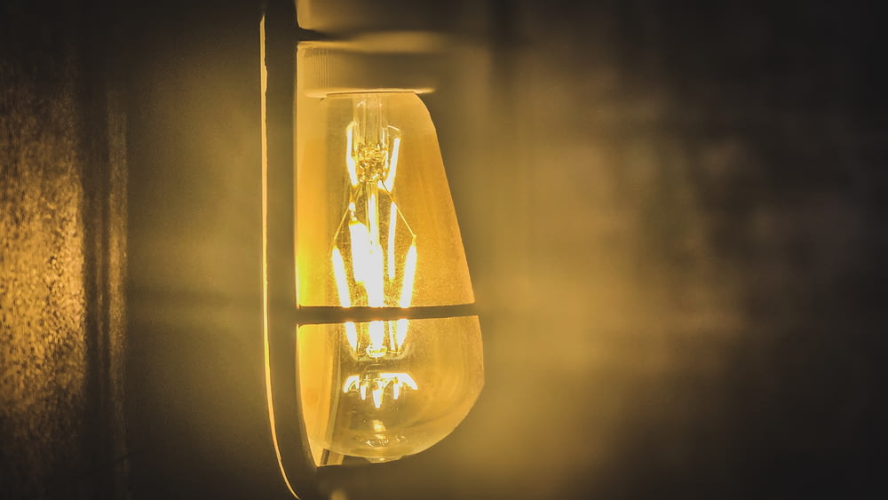 turned-on yellow Edison light bulb