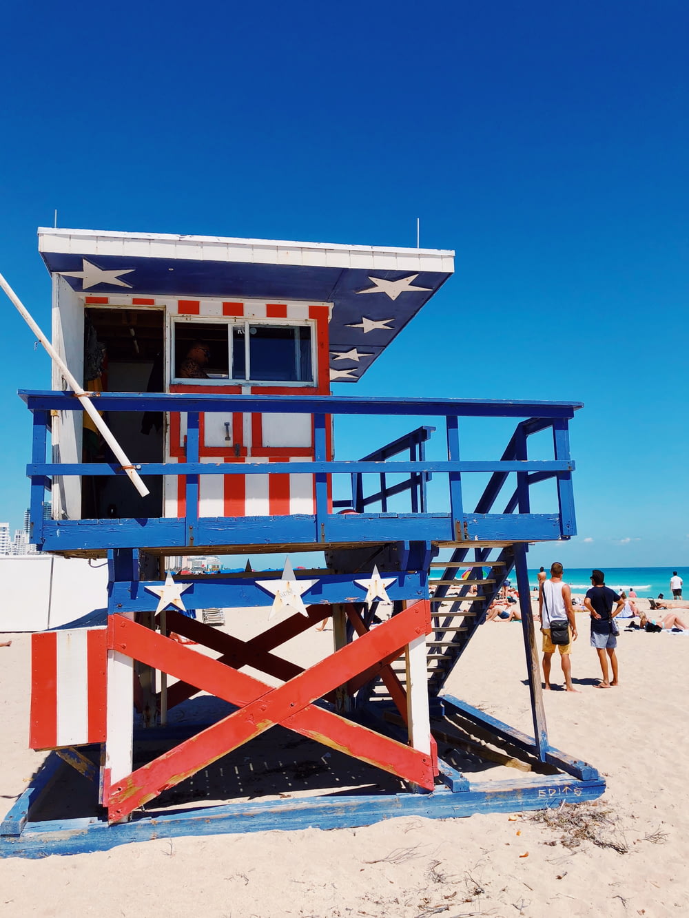 white, blue, and red American flag printed wooden lifeguard house on beach