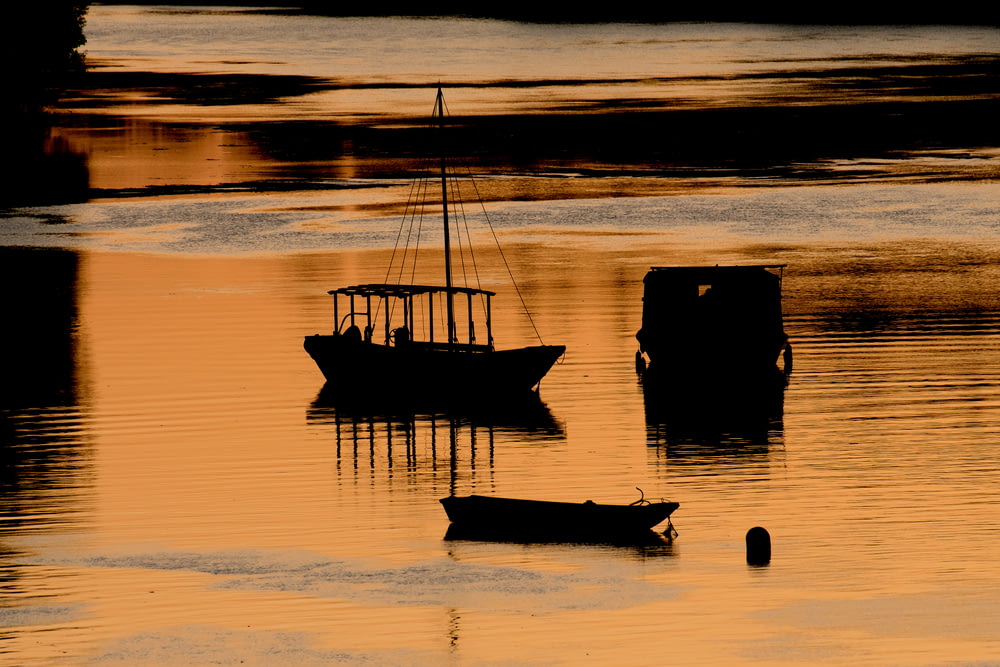 Zwei Boote auf ruhigem Gewässer während der goldenen Stunde
