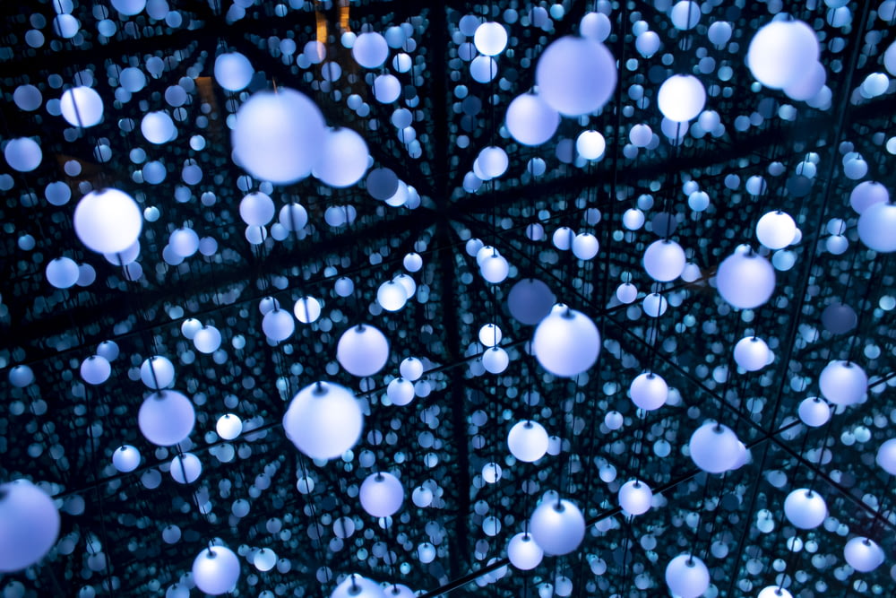 a bunch of white balls hanging from a ceiling