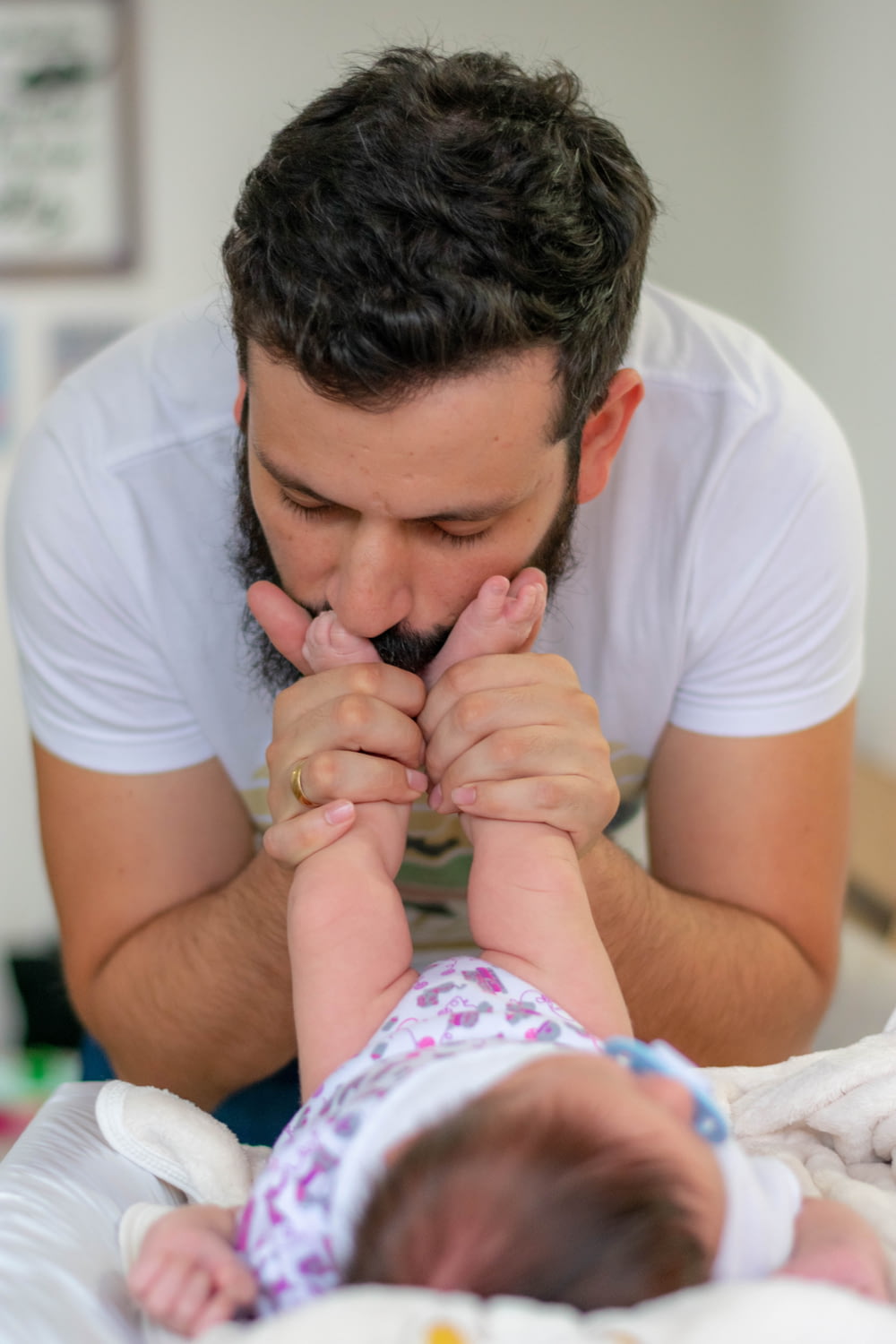 homem beijando os pés do bebê