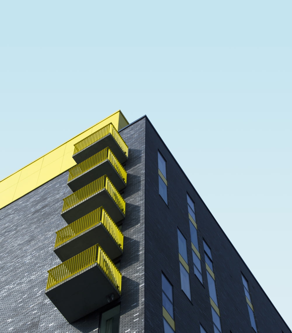 Edificio amarillo y negro bajo el cielo azul durante el día