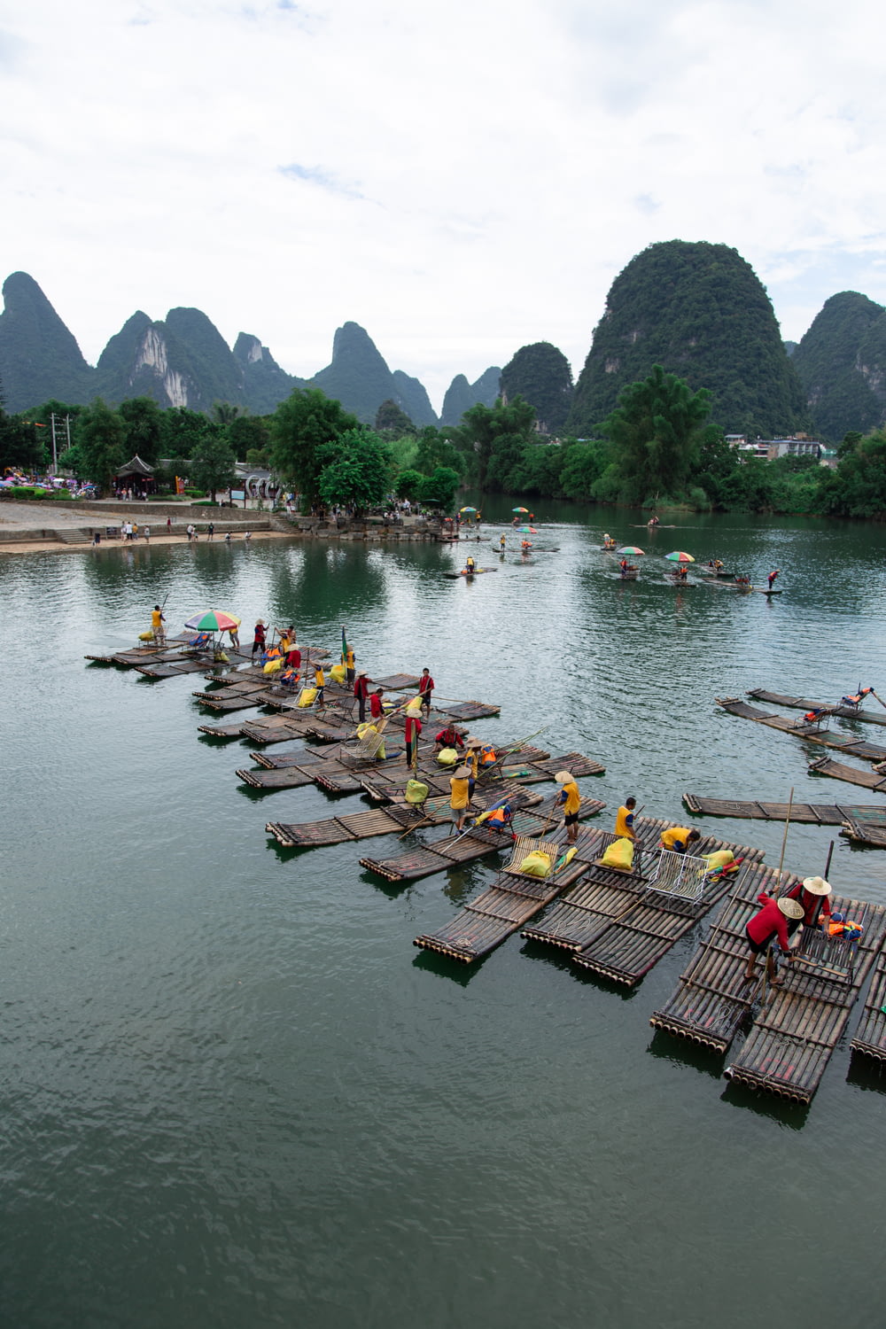 a group of people standing on wooden rafts in a body of water
