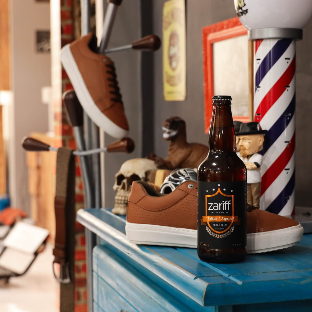 low-top shoe and Zariff beverage bottle on top of blue wooden cabinet