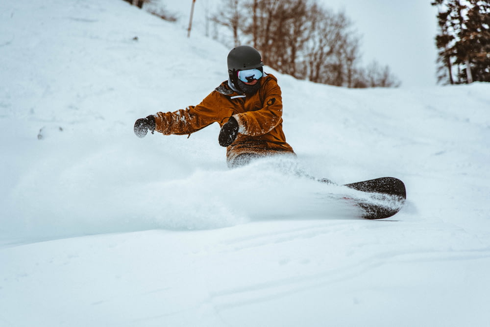Fotografía de una persona jugando al snowboard durante el día