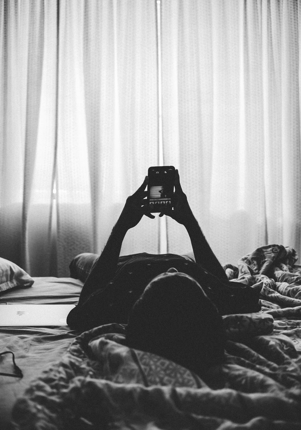 ベッドに横たわる男性とスマートフォン