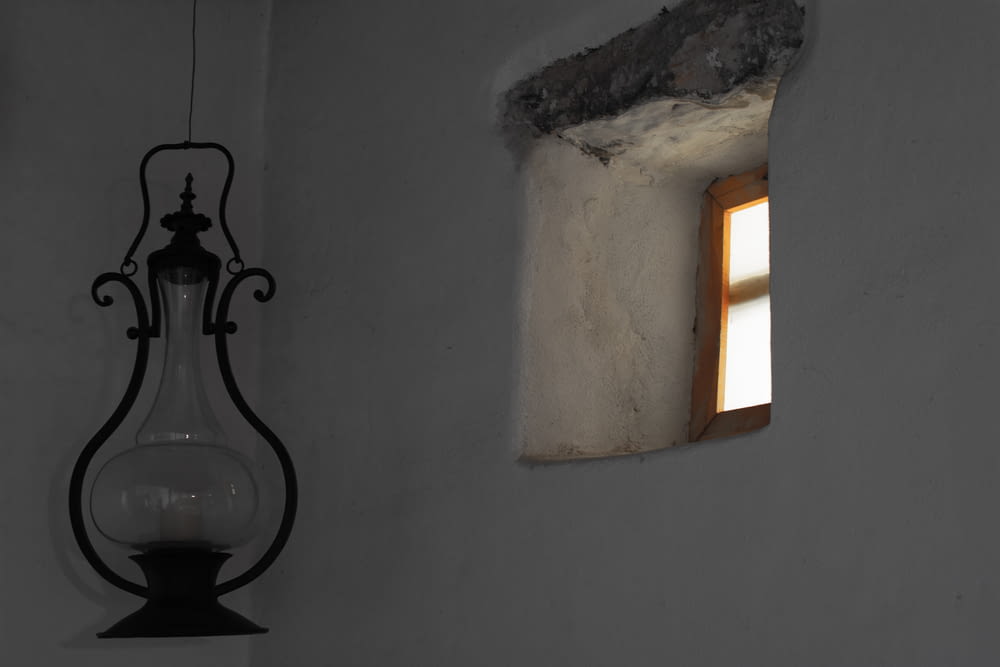 black metal lantern besides small window