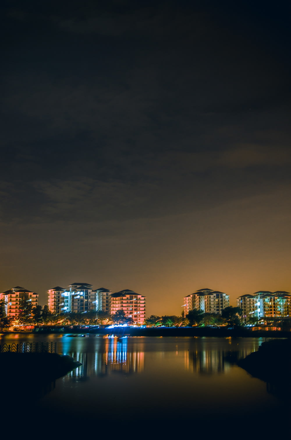 Spiegelung der Skyline der Stadt auf einem Gewässer während der Nacht