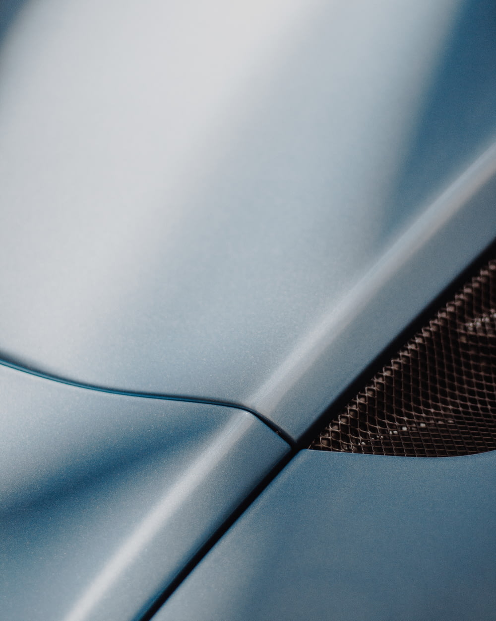 a close up of the hood of a blue sports car