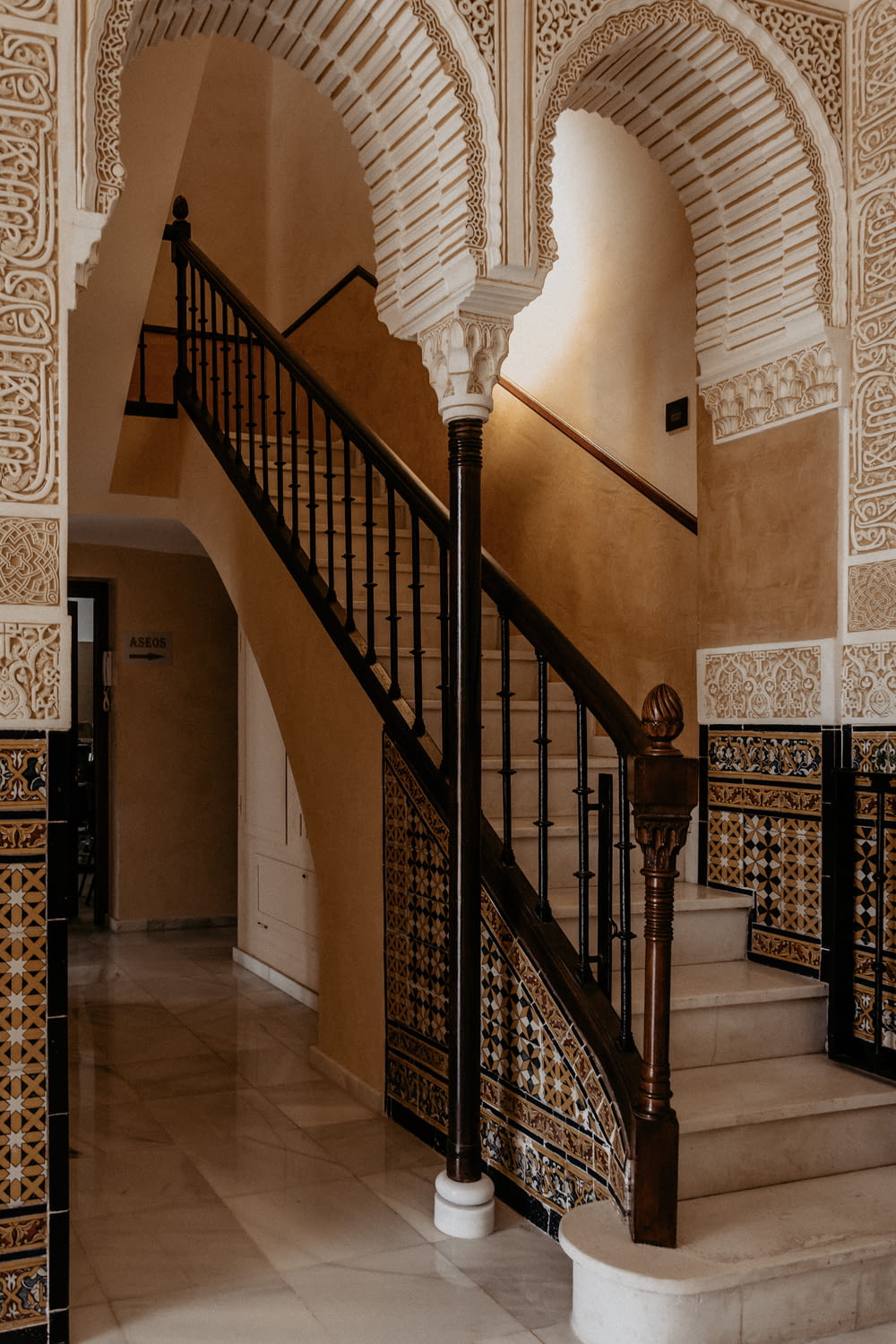 a staircase in a building with a wrought iron railing