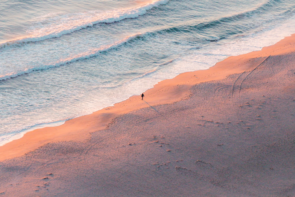 Vista aérea de la persona de pie en la orilla del mar