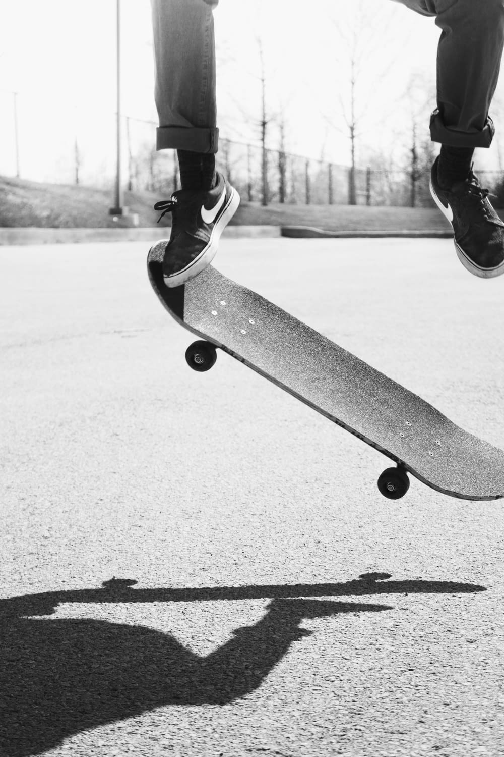 grayscale photo of person playing skatebaord