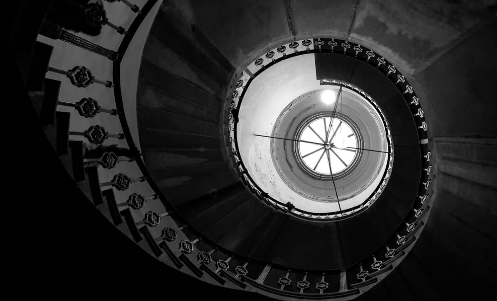 a black and white photo of a spiral staircase