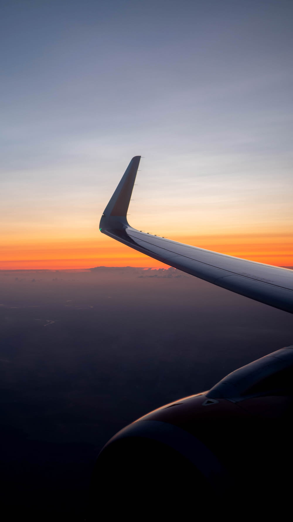 L'ala di un aeroplano mentre il sole tramonta