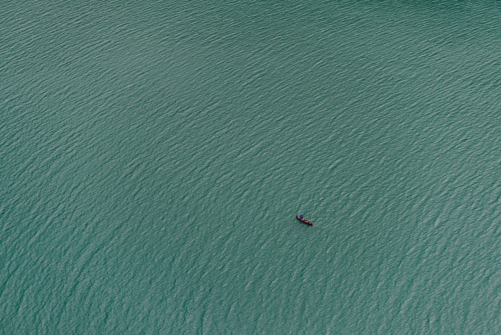 a lone boat in the middle of a large body of water
