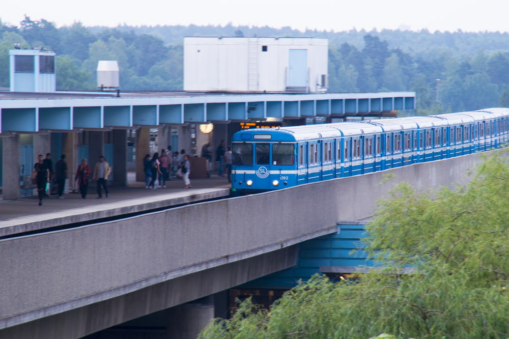 a blue and white train pulling into a train station