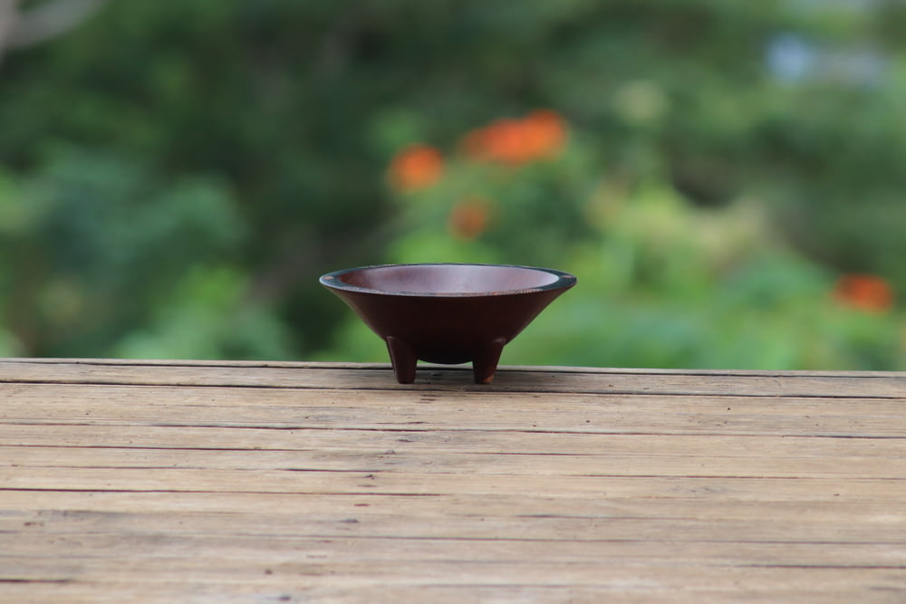 round brown bowl on wooden surface