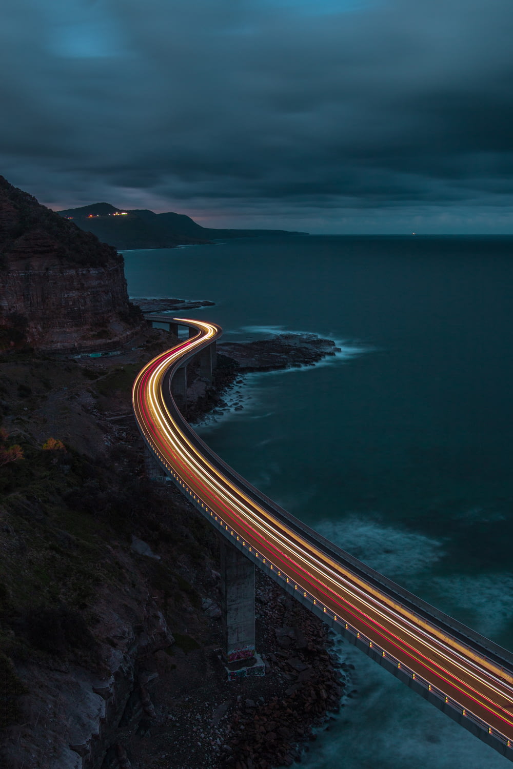 a long exposure photo of a highway going over the ocean