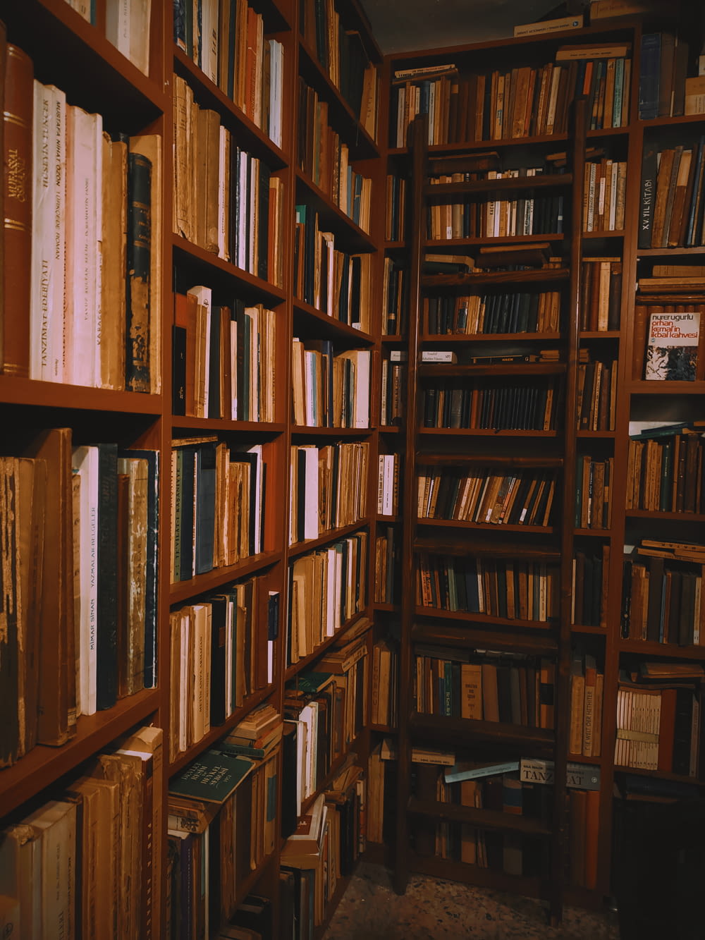 books stacked on wooden shelves in a library