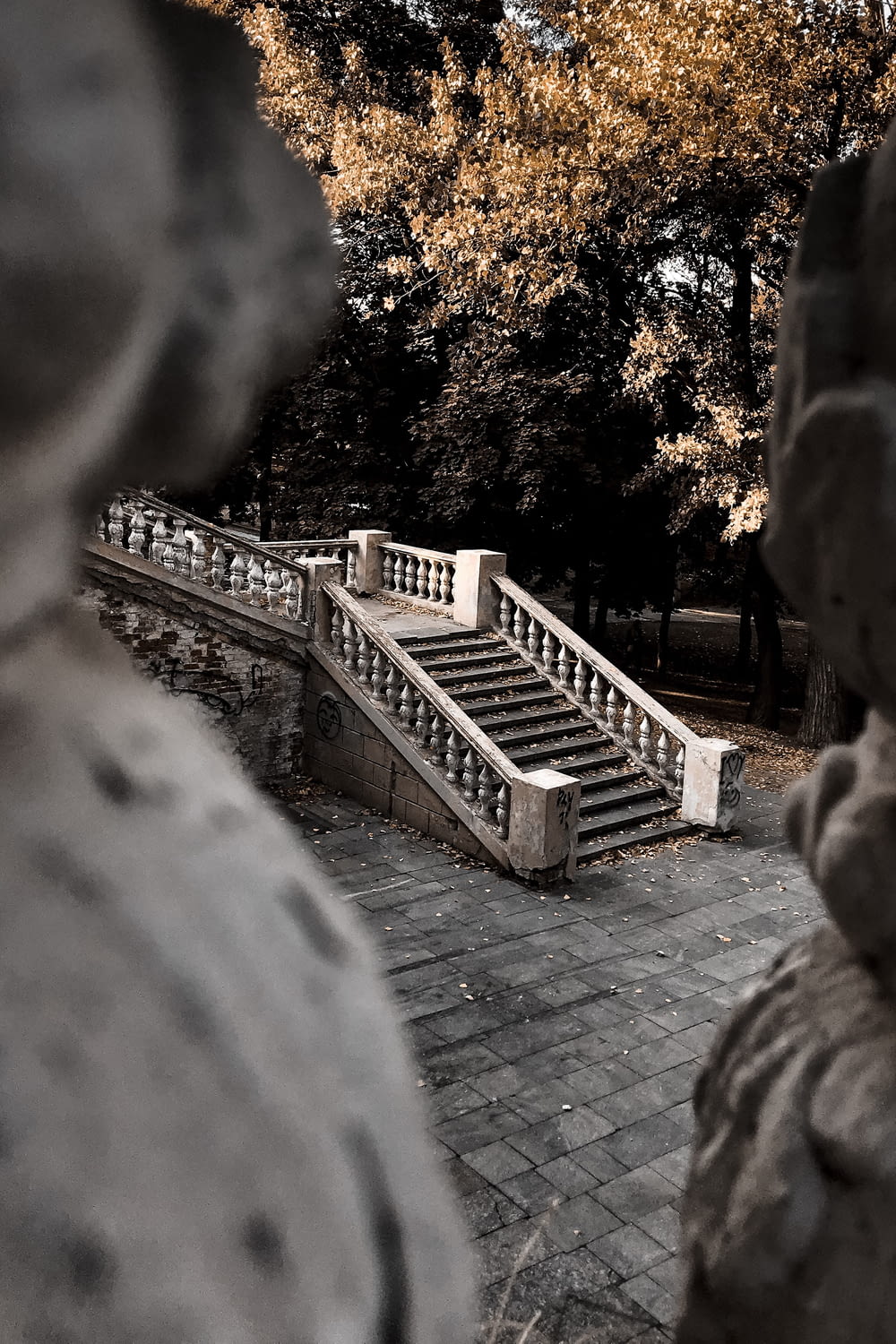 a statue of a person sitting on a bench next to a set of stairs