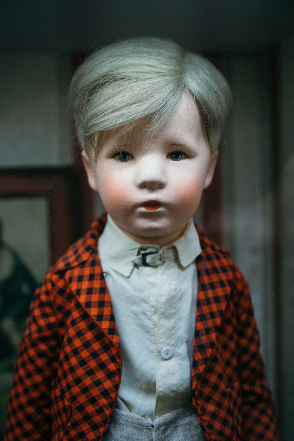 boy doll wearing orange and black checkered top