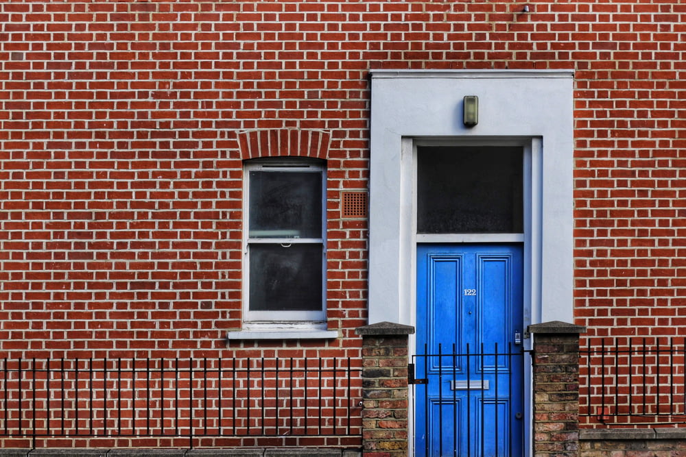 red brick building with closed door and window