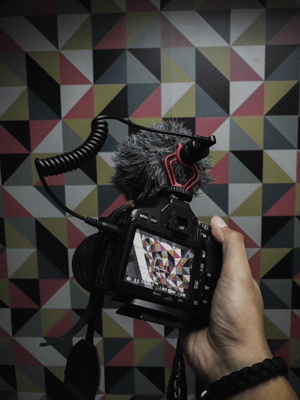 person holds DSLR camera with stereo recording cardioid microphone