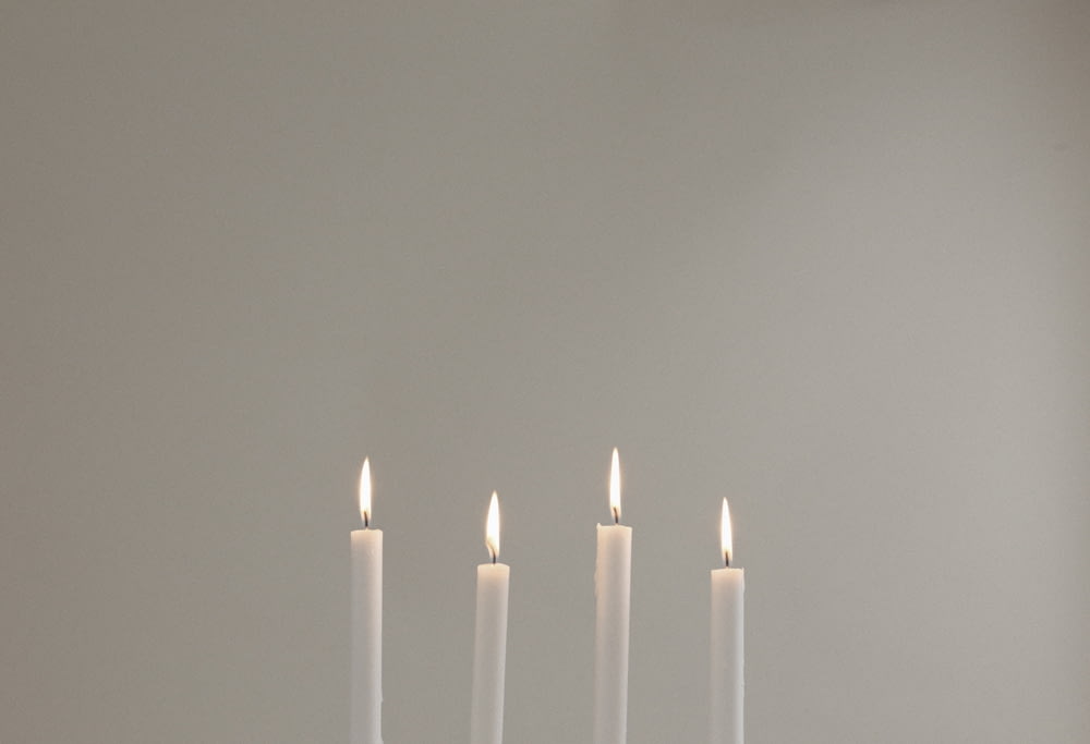 four lighted white candles