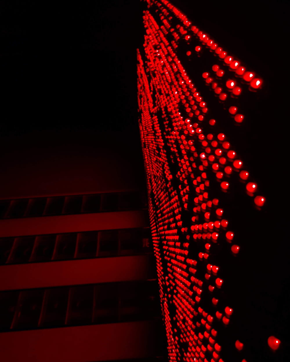 a building lit up with red lights in the dark