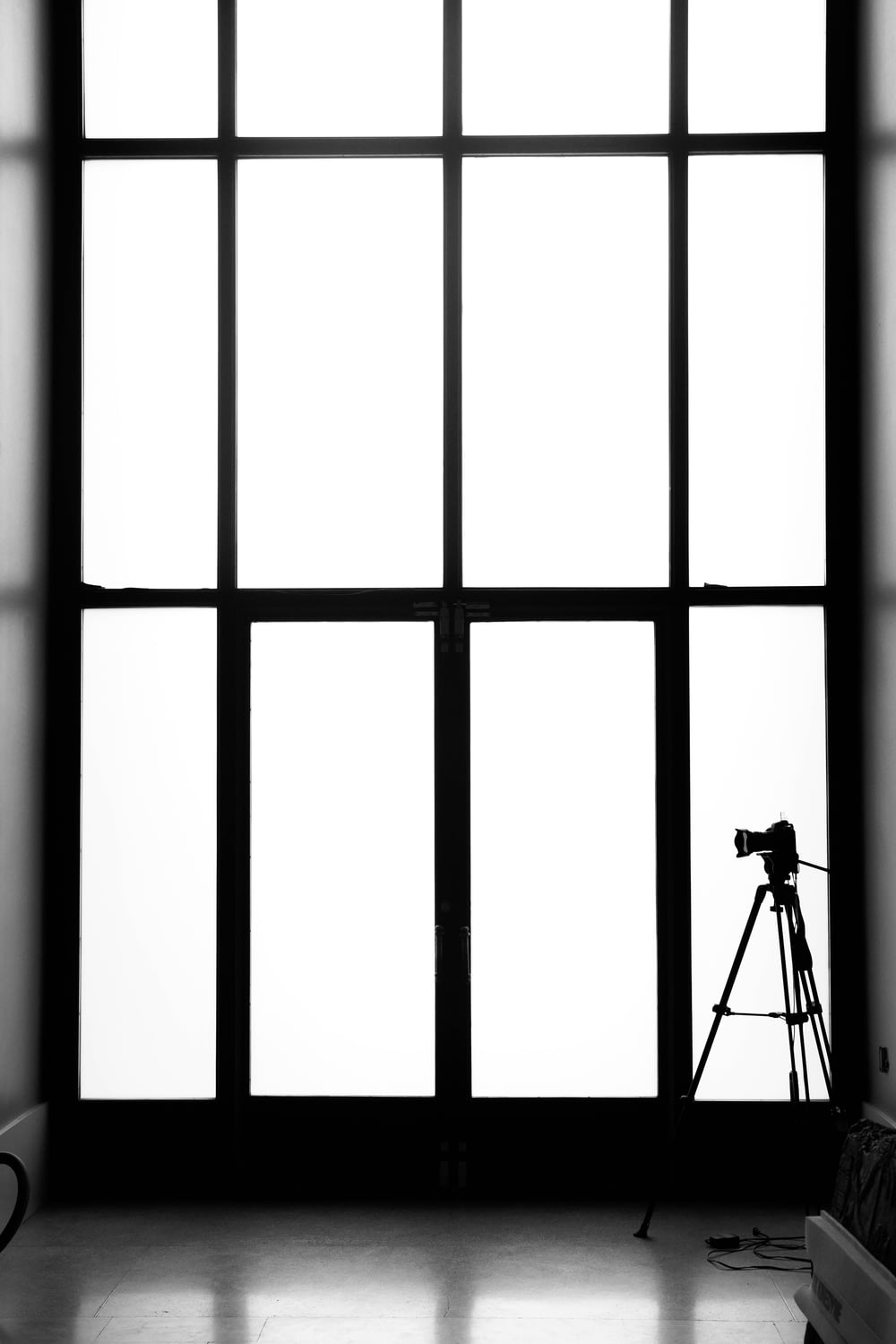 grayscale photography of tripod and camera