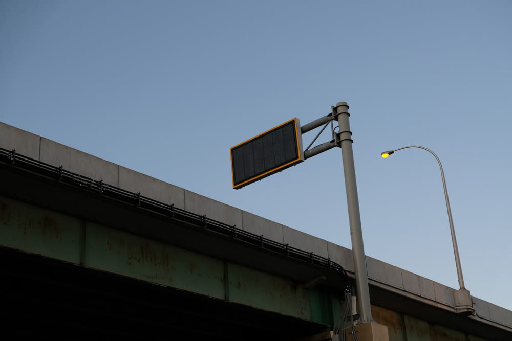 a street sign on a pole next to a bridge