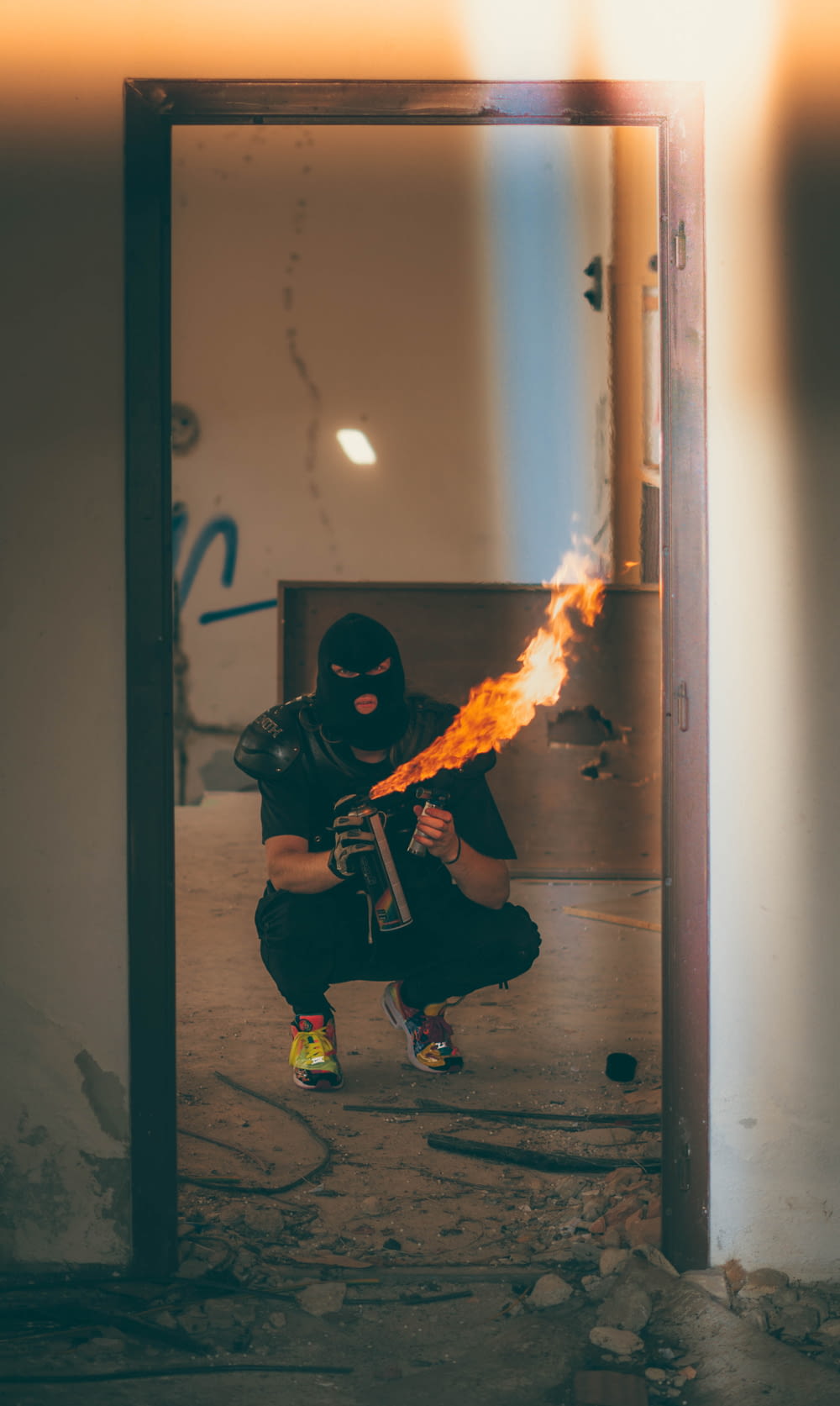 Homme portant un masque de bonnet noir tenant un flacon pulvérisateur de feu