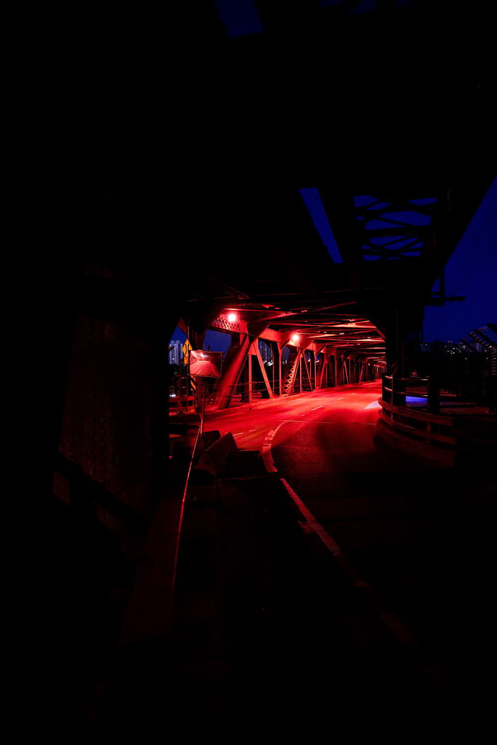 a red light shines on a bridge at night