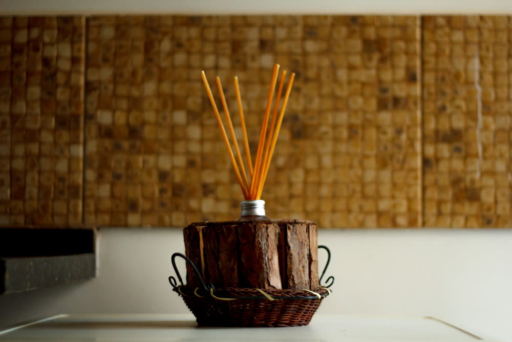 a basket with reeds in it sitting on a counter