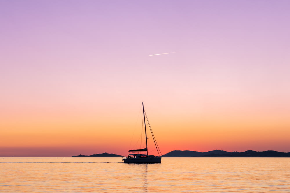 sailboat in sea during golden hour