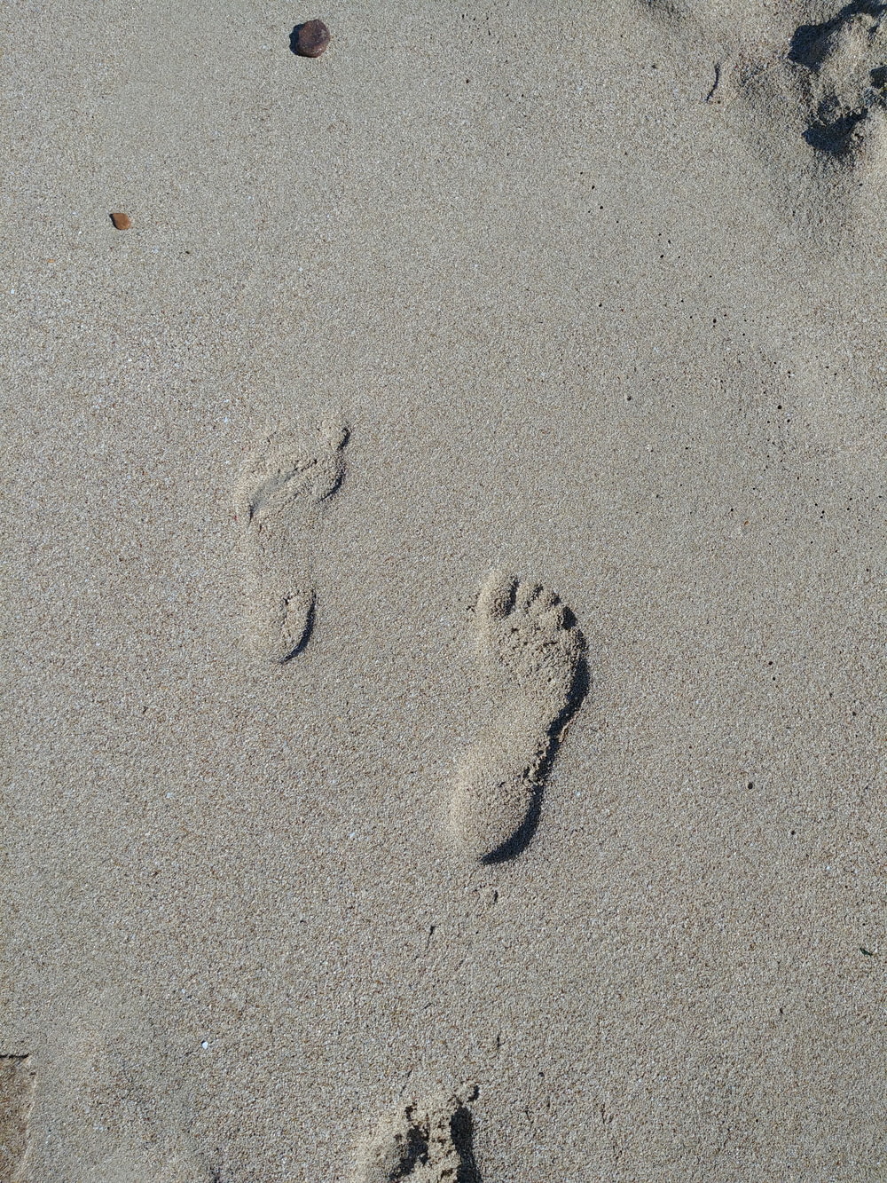 a pair of footprints in the sand on a beach