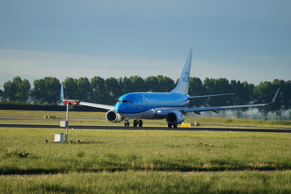 Avião azul no aeródromo durante o dia